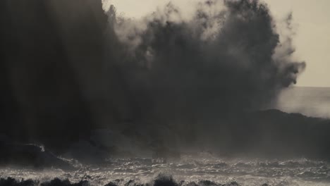 blue waves roll into the coast of hawaii and crash into the shore in slow motion during a big storm