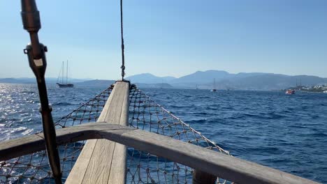 wooden bow view on a big sailing boat in bodrum turkey, fun summer vacation, the front of a moving boat, luxury holiday destination, sunny sea day with blue sky, 4k shot