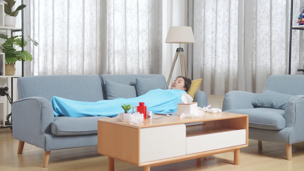 질병으로 인해 소파에서 휴식을 취하는 여성