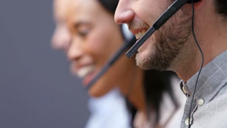 Smiling-customer-service-executives-talking-on-headset-at-desk-4k