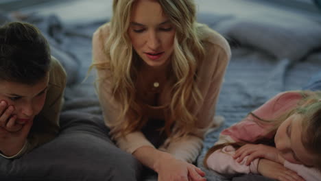 Mother-spending-time-with-kids-at-home.-Daughter-son-listening-mom-reading.