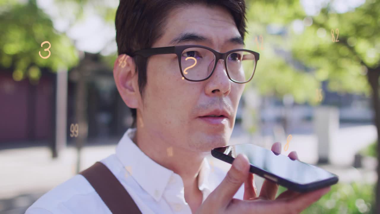 Mature man raising smartphone and speaking for voice input, camera pulling back revealing bag strap