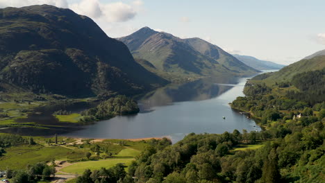 Reveladora-Toma-De-Drones-Del-Viaducto-De-Glenfinnan-Con-Agua-Y-Montañas-En-El-Fondo