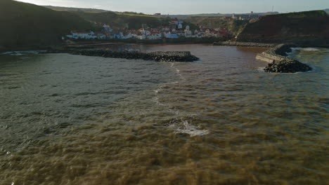 low establishing drone shot of staithes village and harbour yorkshire uk