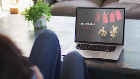 Knees-of-woman-at-table-using-laptop,-online-shopping-during-cyber-monday-sale,-slow-motion