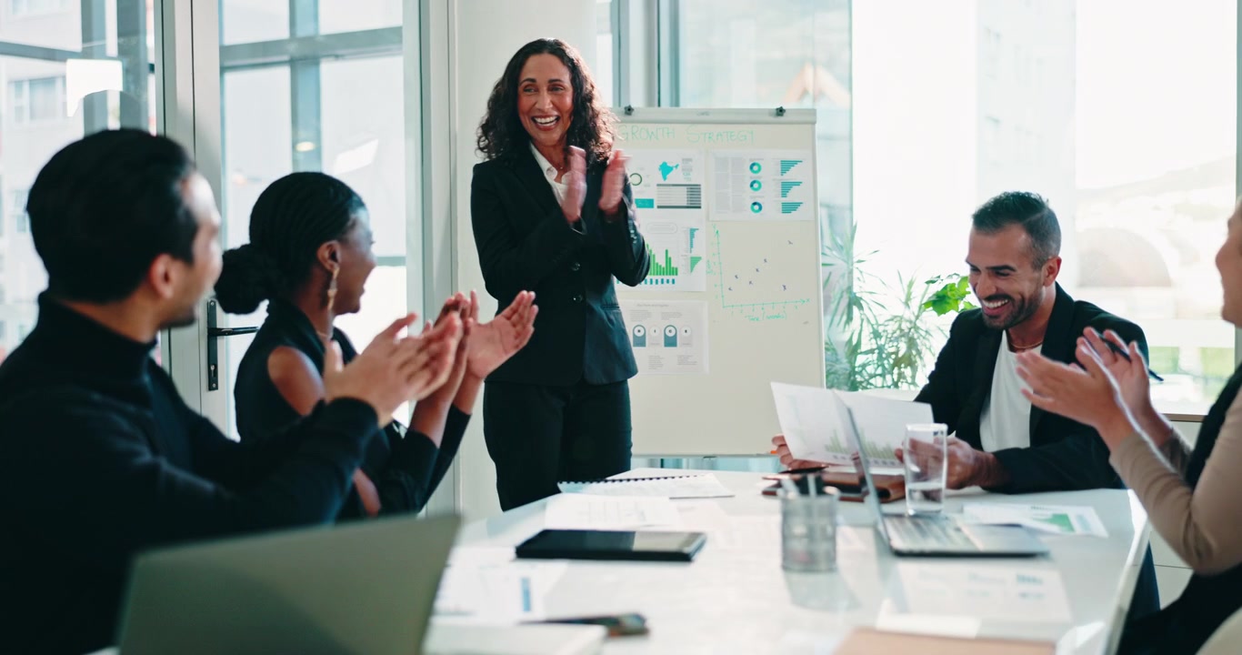 Business Team Applauding Female Colleague During Presentation in Office