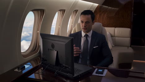 man using computer on a private jet