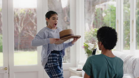 happy father dancing with teenage daughter having fun enjoying playful dance enjoying weekend celebration at home wearing pajamas