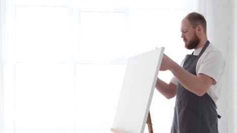 the young talented artist paints on a large white canvas creates a colorful - the young talented artist paints on a large white canvas, creates a colorful, emotional, tangible oil painting. contemporary artist creates abstract contemporary art in a white studio