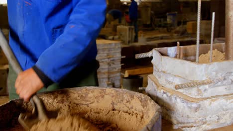 worker putting soil in molds in foundry workshop 4k