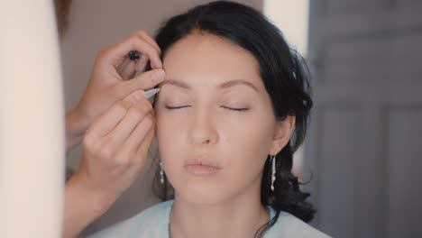woman getting her eyebrows threaded