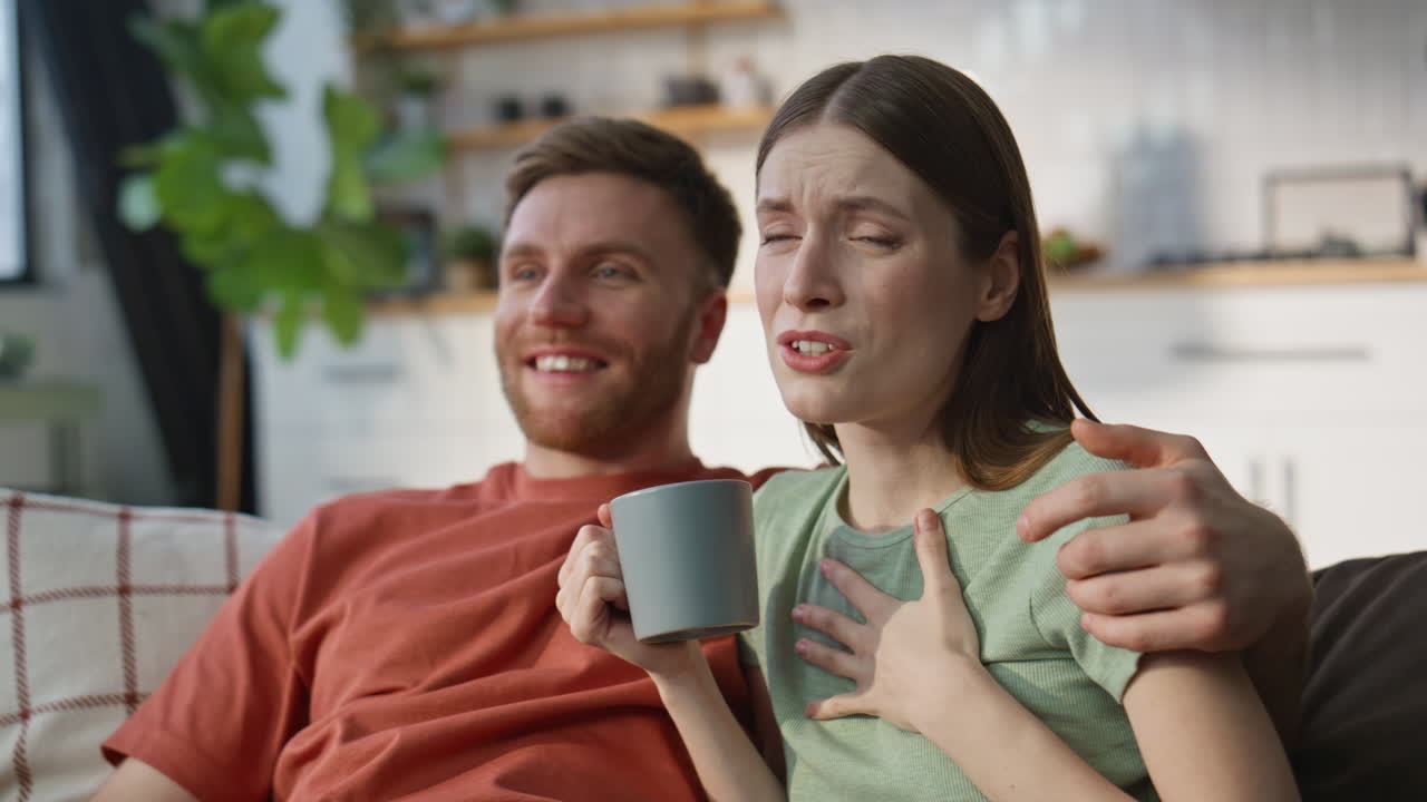 Emotional couple watching serial at home sofa closeup. Married woman and man