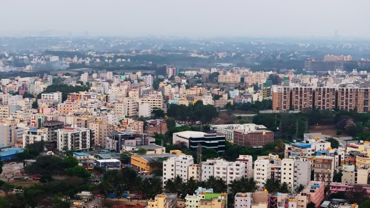 Edifici residenziali con appartamenti, alberi, foschia e cielo a Silicon Town, Electronic City, Bengaluru, Karnataka, India. Di giorno, ripresa a semicerchio, ripresa con drone, 4K.