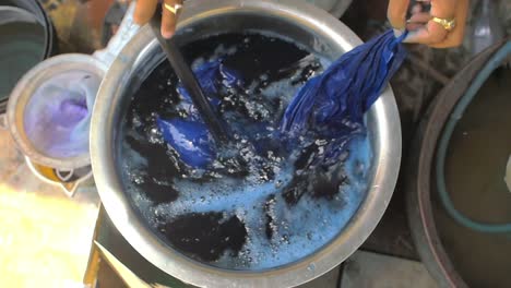 man hand dyeing clothes blue