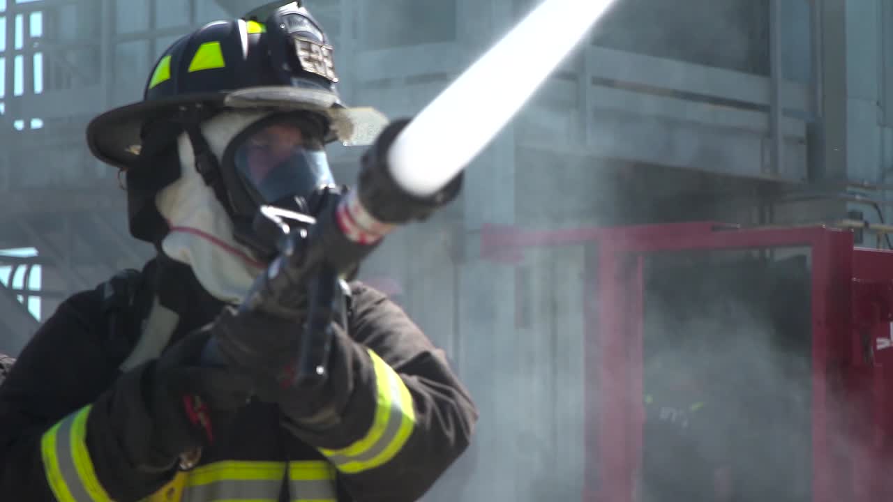 bomberos de las fuerzas armadas entran a un edificio en llamas