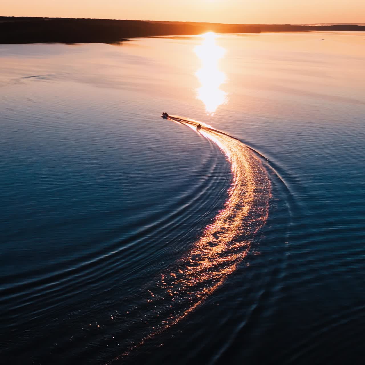 Boat on beautiful river at sunset. Moving boats against the golden path from the evening sun. Aerial view.