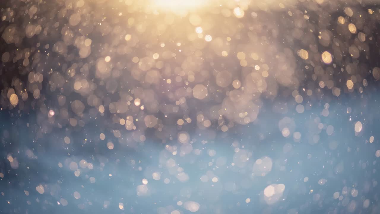 Drifting backlit snowflakes catching low sun flare at snowy field, producing soft glowing bokeh