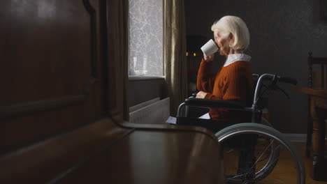 mujer mayor en silla de ruedas con factura de energía por radiador en el costo de la vida crisis energética