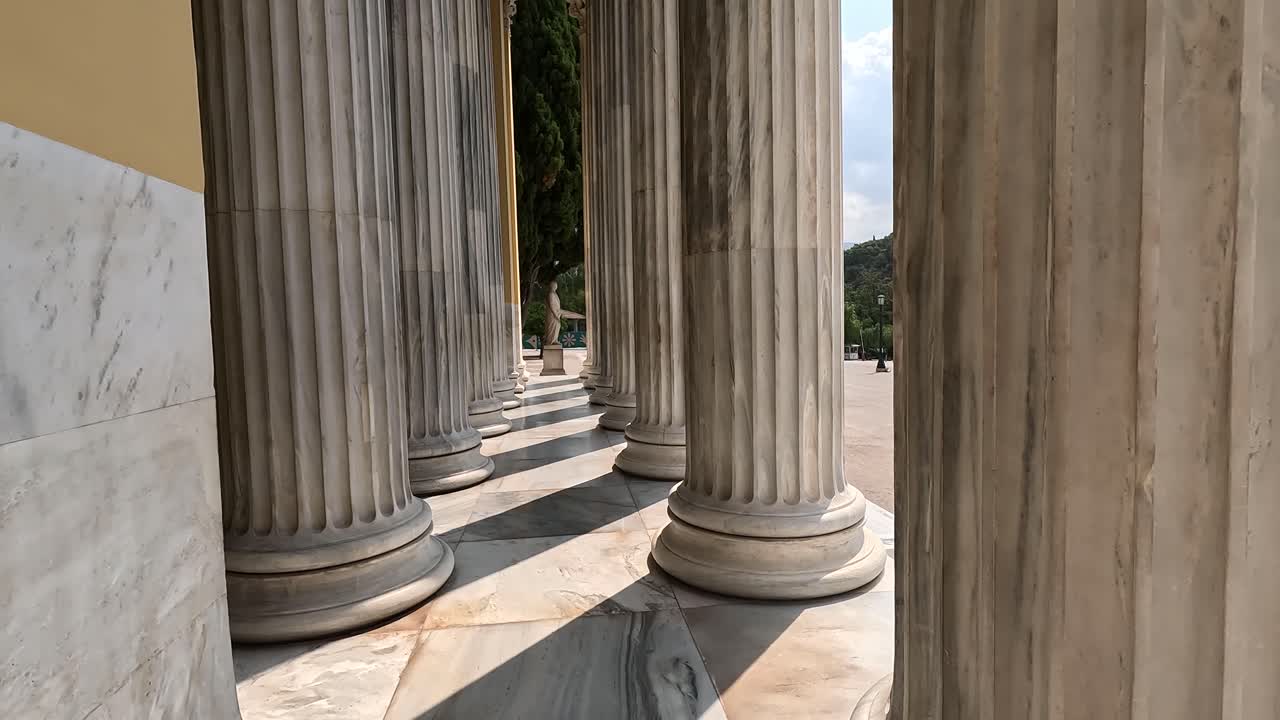 Walking through pillars of a Greek building.