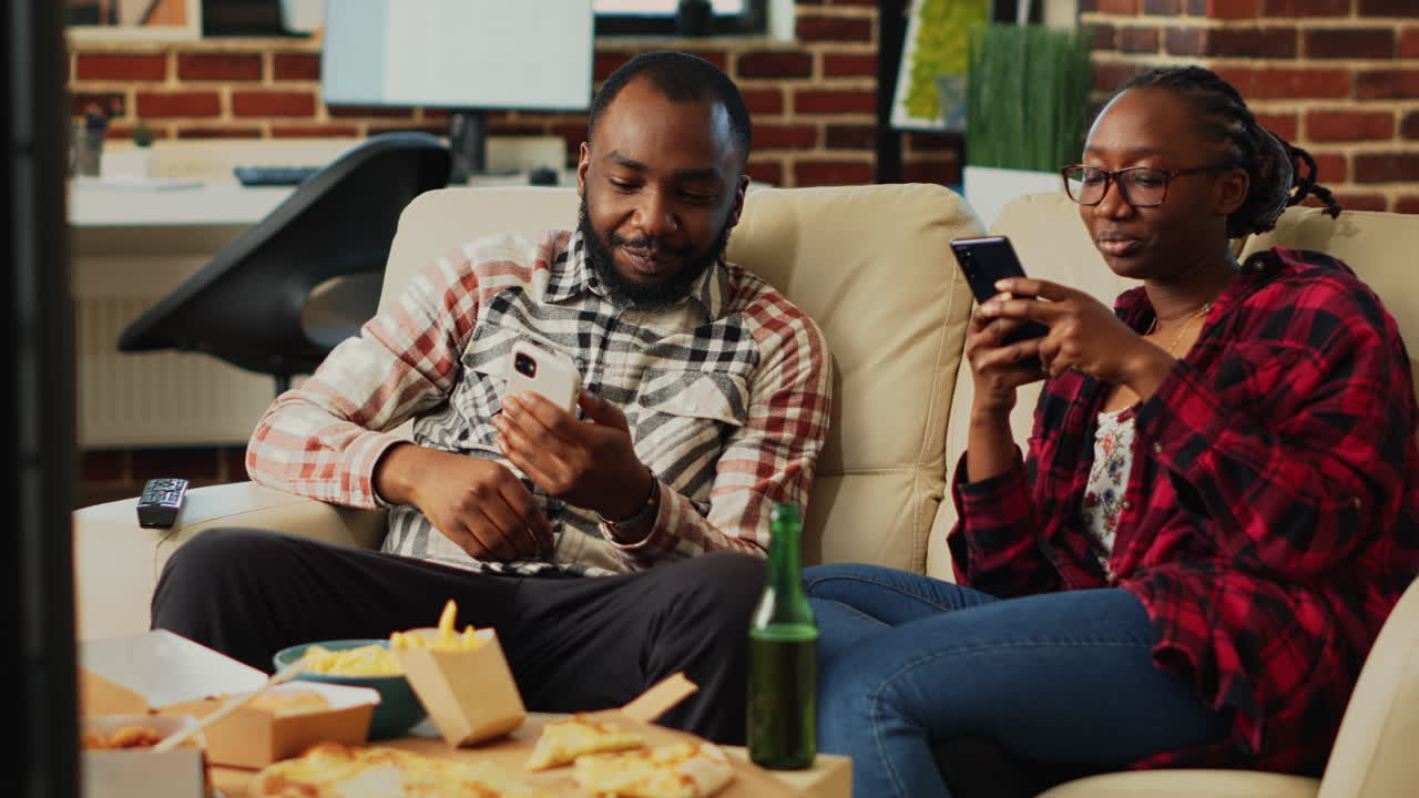 African american couple browsing apps on smartphones