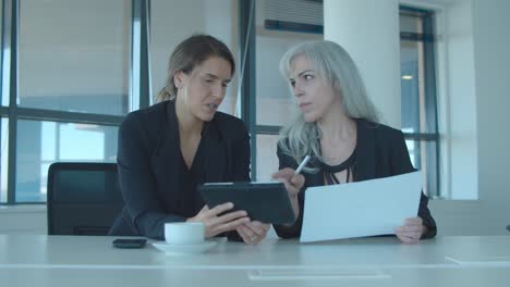 Serious-business-ladies-checking-and-analyzing-reports