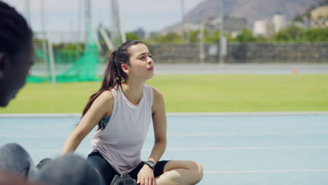 jóvenes atletas estirando las piernas tocándose