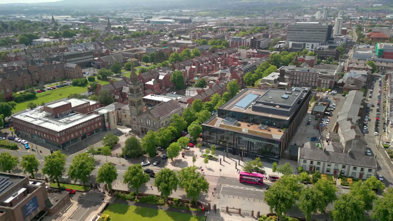 Wide, forward travelling aerial video of Queen's University Belfast and the surrounding campus on a bright and sunny day. Produced at 4K resolution, 60FPS and with Rec709 color.