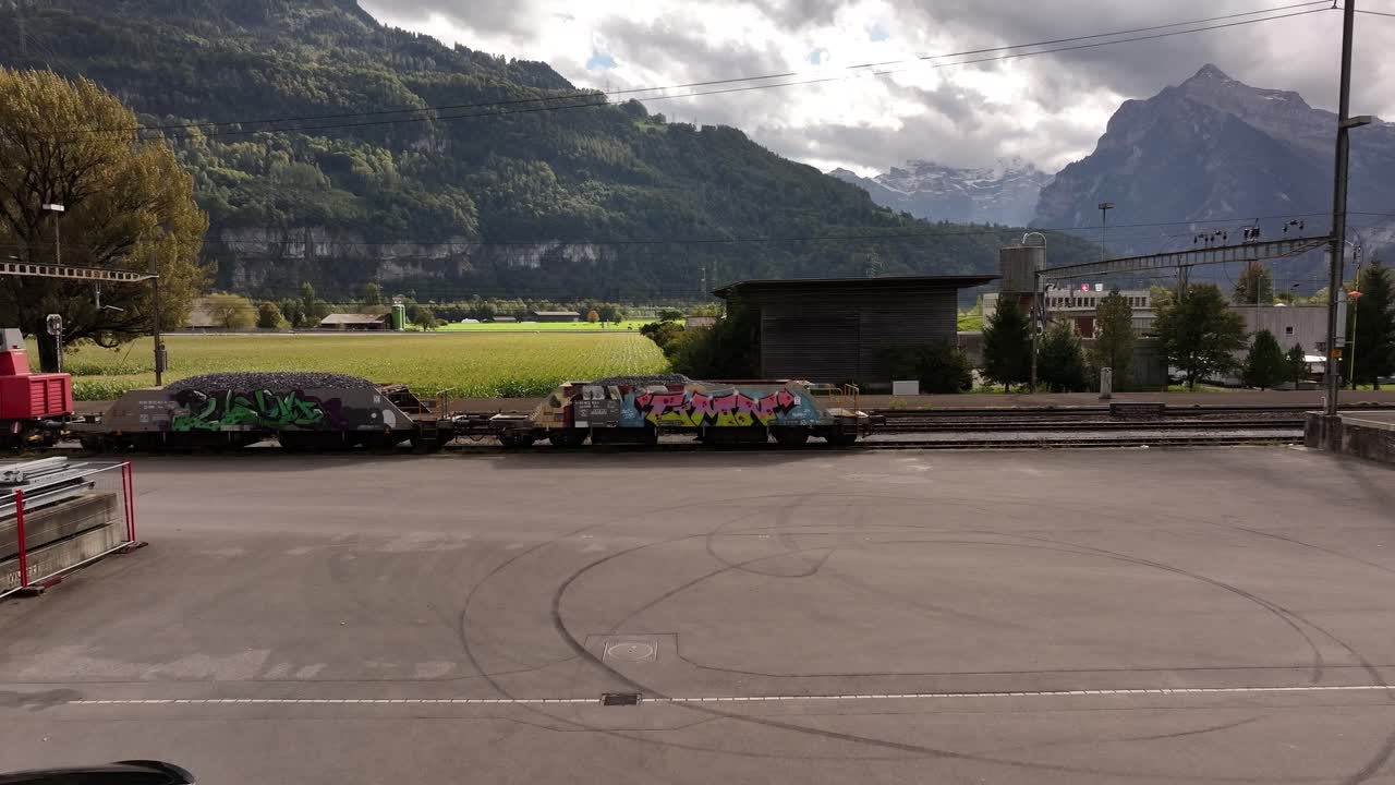 Graffiti-covered Freight Train in Swiss Mountain Scenery