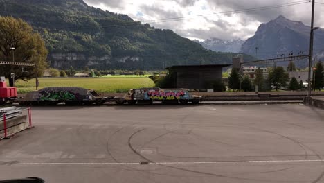 graffiti-covered freight train in swiss mountain scenery