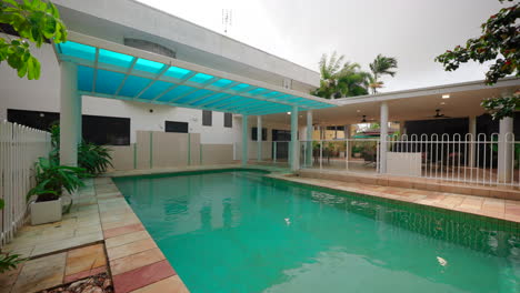 grand large home pool reveals shimmering blue water reflecting glass awning covering of sleek white house