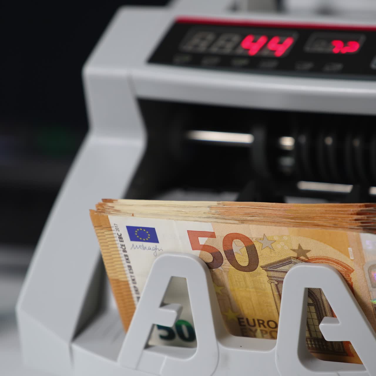 Modern electronic money counting machine working. Fifty euro banknotes being counted quickly. Close up