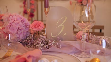 Mesa-De-Boda-Elegante-Cartel-Numérico-Con-Flores-Rosas,-Cena-Romántica