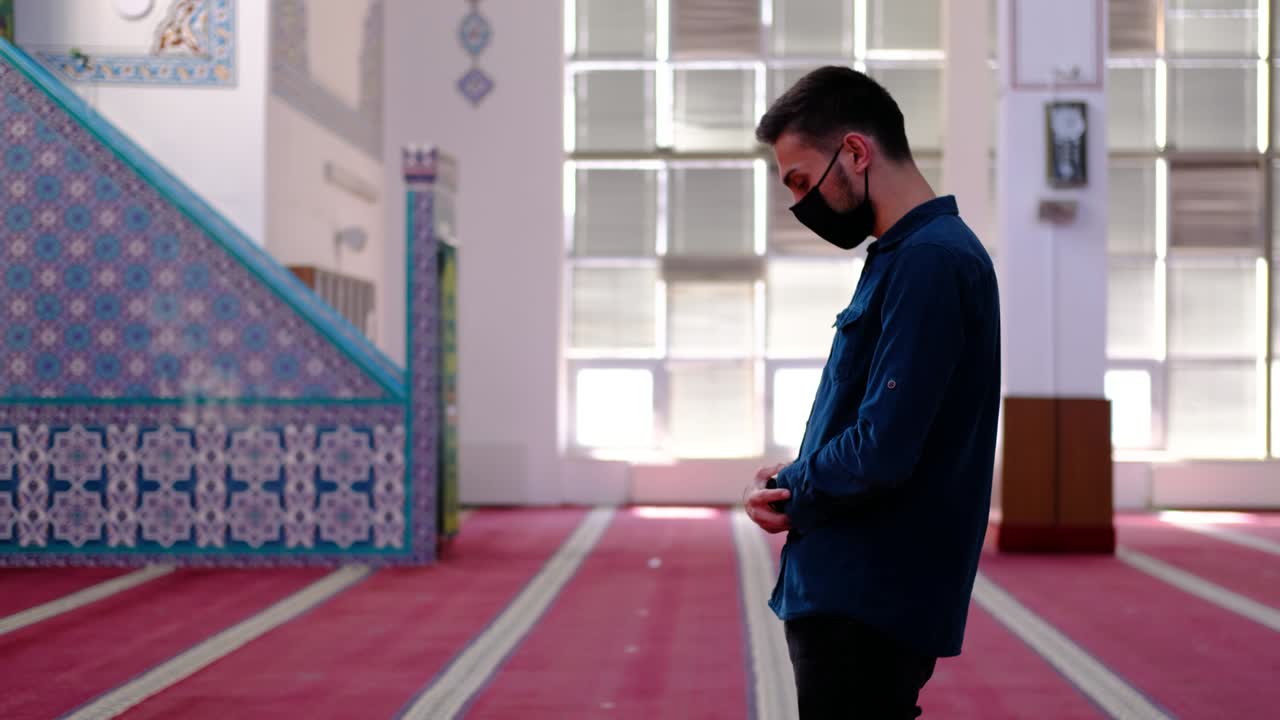 마스크를 쓴 젊은 무슬림이 모스크를 배했습니다.