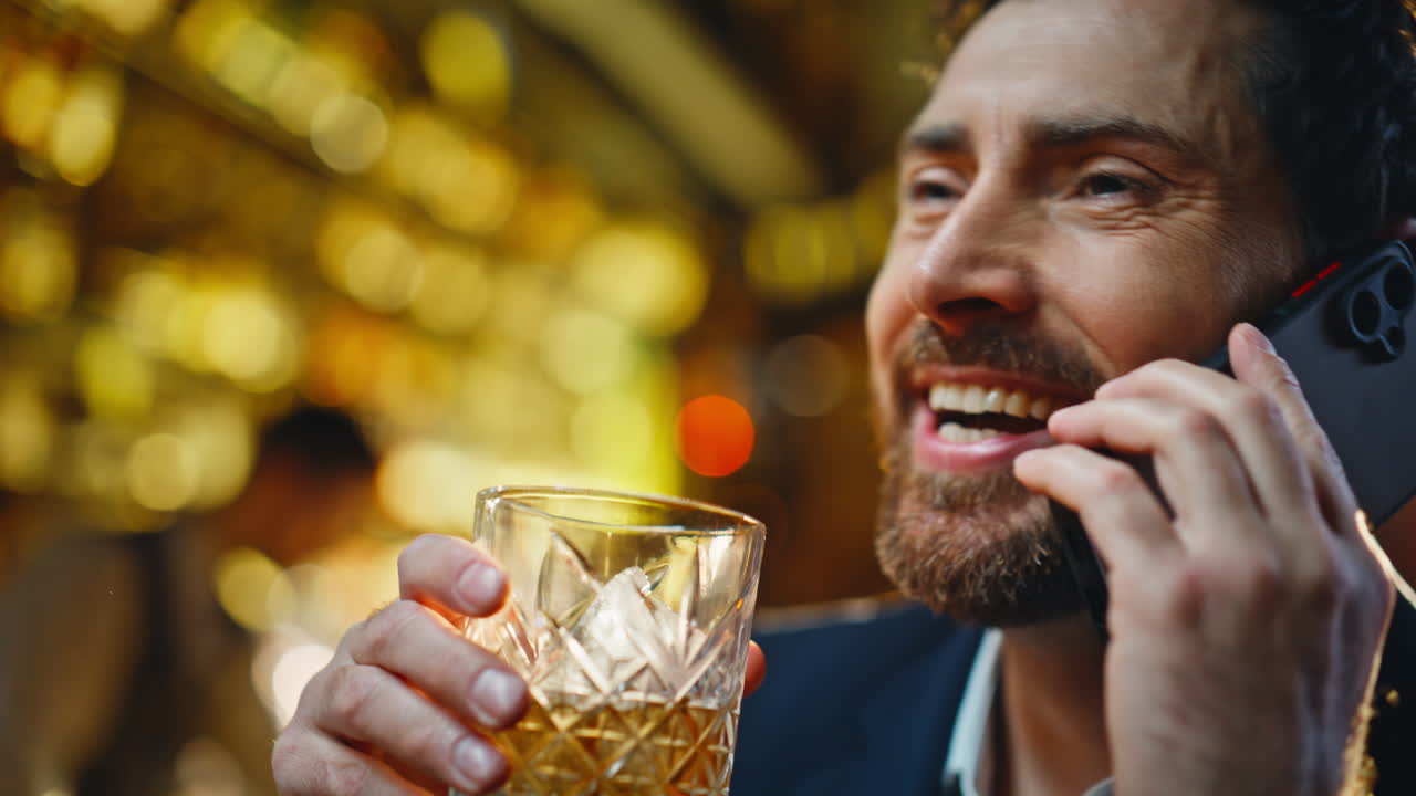 Mano che prende un bicchiere di whisky per un ritratto serale. Un uomo d'affari che sorseggia alcolici