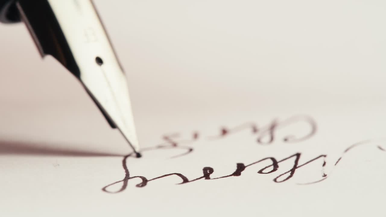 Fountain Pen Writing 'Merry Christmas' on White Paper