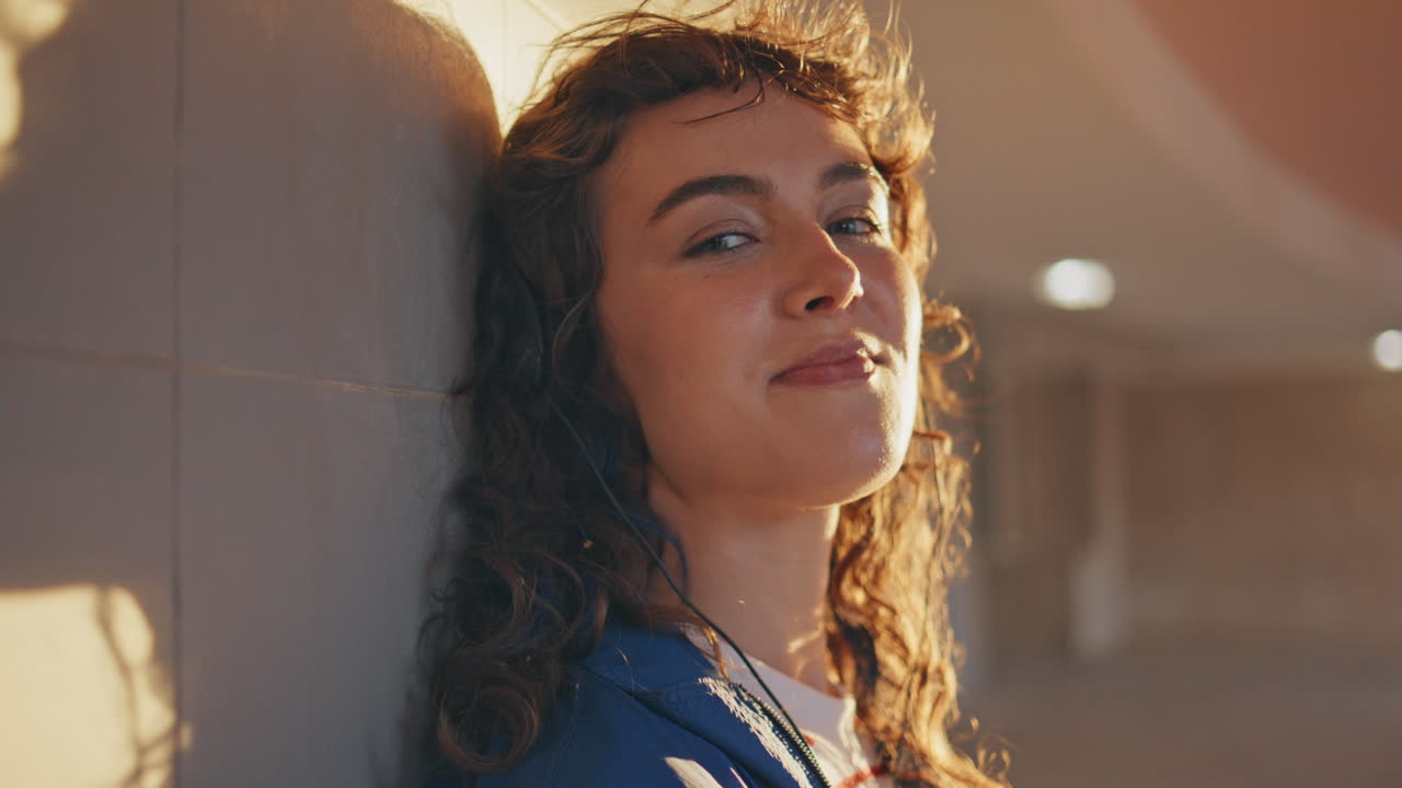 retrato hermosa melomaniaca posando a la luz del sol de la noche. mujer escuchando música