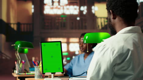 young man medical student does research for exams next to chroma key