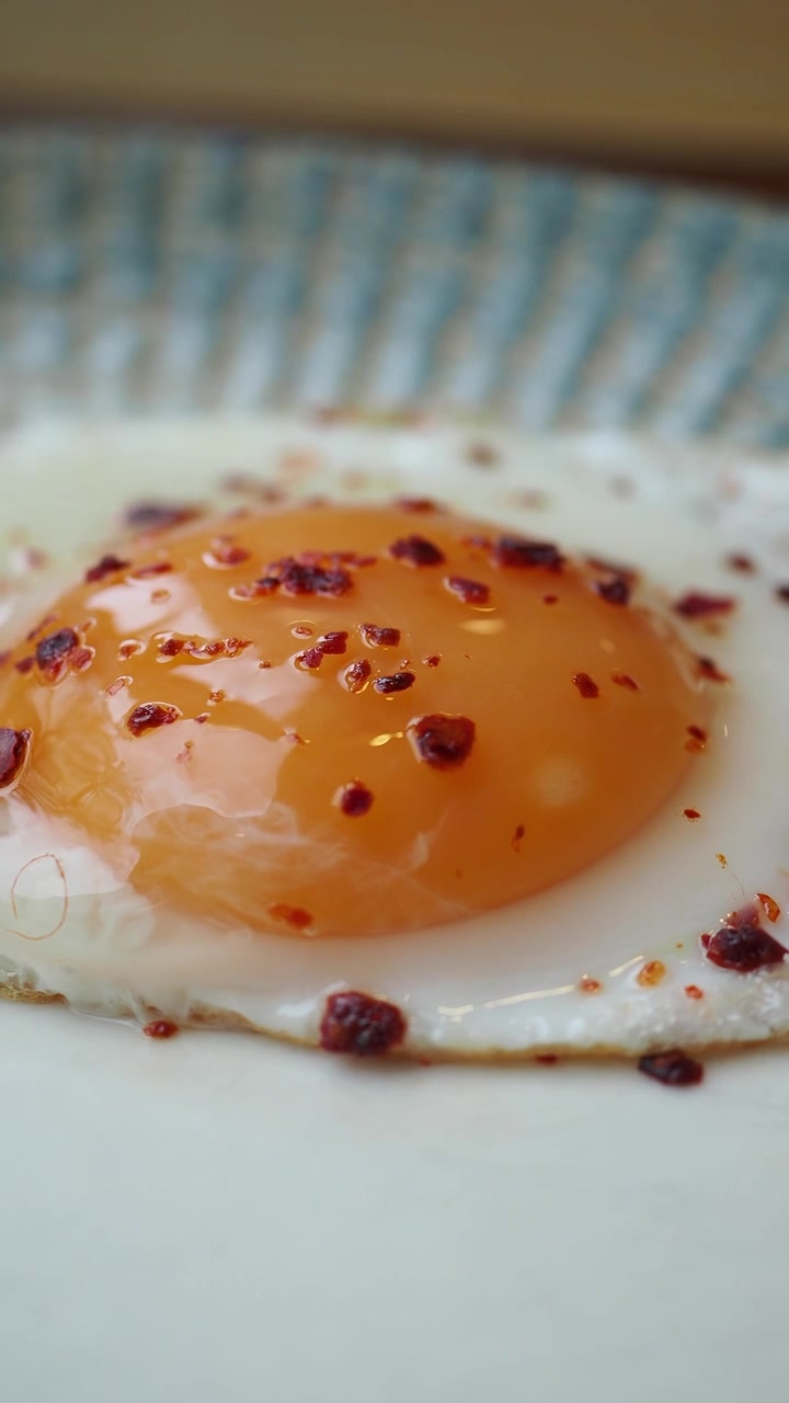 Close-up Telur Goreng dengan Serpihan Cabai di Atas Piring