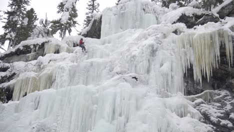 man repelling on a big frozen waterfall - ice climbing - still shot