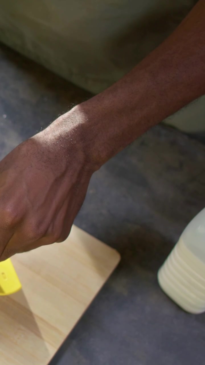 Video verticale: Appoggiando una spatola, uomo con grembiule verde che prende una frusta, mescolando l'impasto in cucina per cuocere
