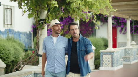 gay couple walking in public garden with blooming trees