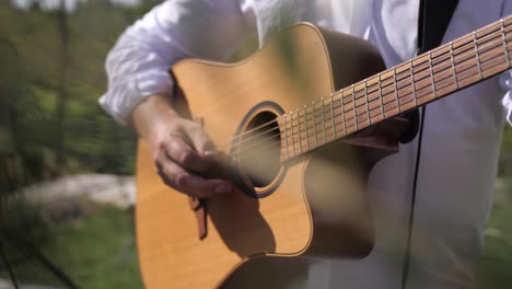 Hombre-Tocando-La-Guitarra,-Primer-Plano-Con-La-Mano,-Al-Aire-Libre,-Día-Soleado-De-Verano,-Recogiendo-Cuerdas