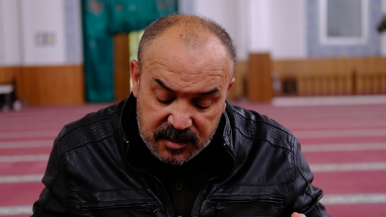 el hombre lee el corán en la mezquita 1