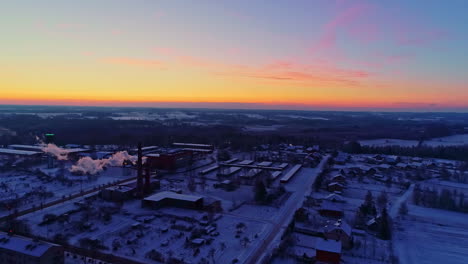 smoke from snow-covered industrial area on winter sunrise