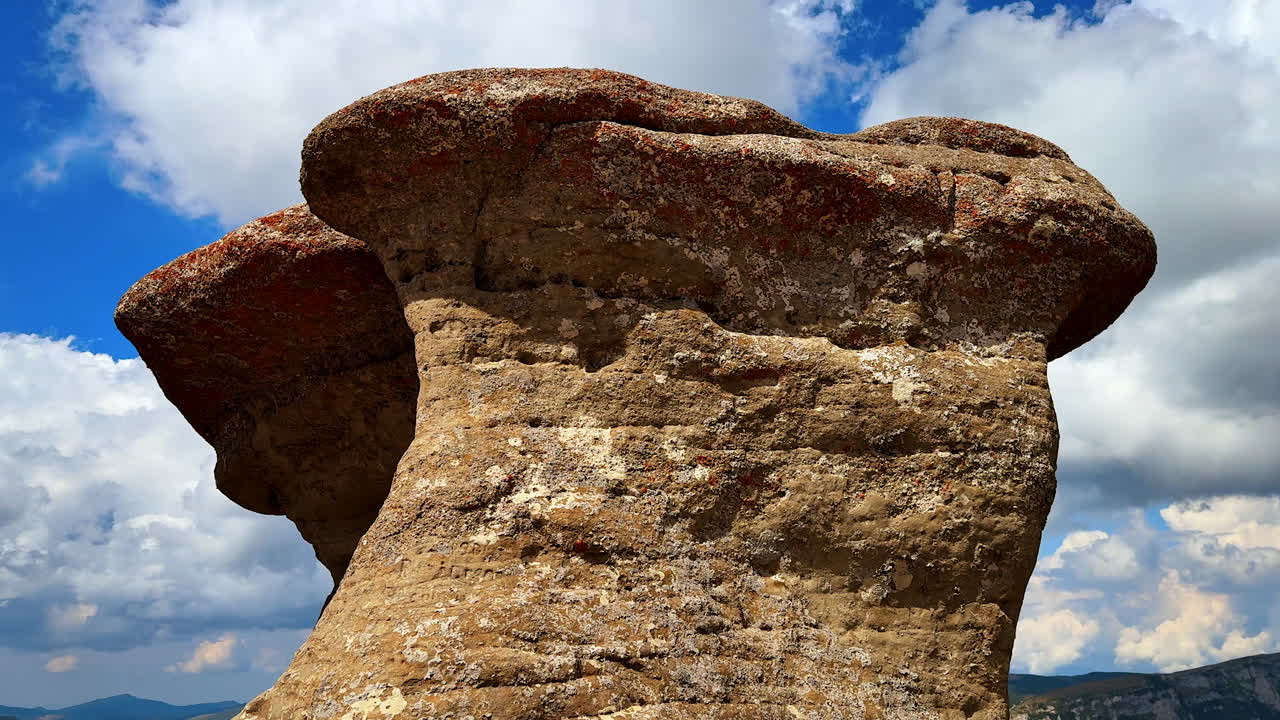 Rock formations under blue sky in Bucegi Mountains. Unique rock formations in the Bucegi Mountains against a vivid blue sky with clouds