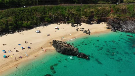 Aerial-view-of-rock-jumpers-in-Waimea-Bay,-North-shore,-Oahu,-Hawaii