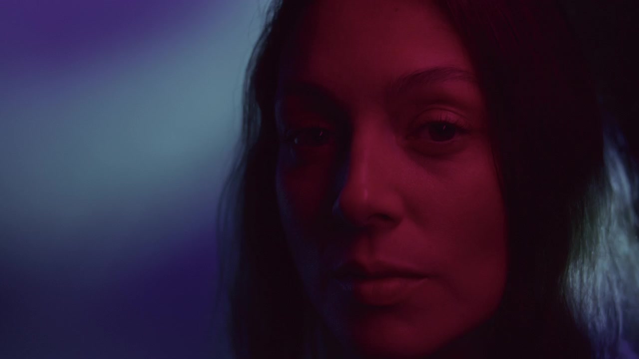 Retrato atmosférico de mujer hermosa bajo luz de neón parpadeante.