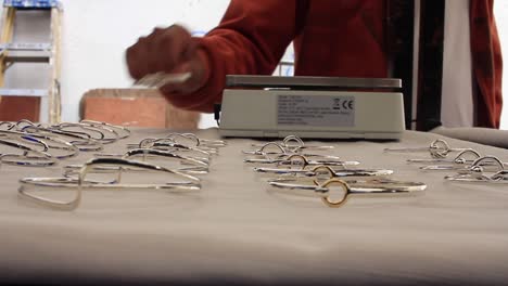 a person is weighing a silver bracelet in a traditional market in taxco guerrero