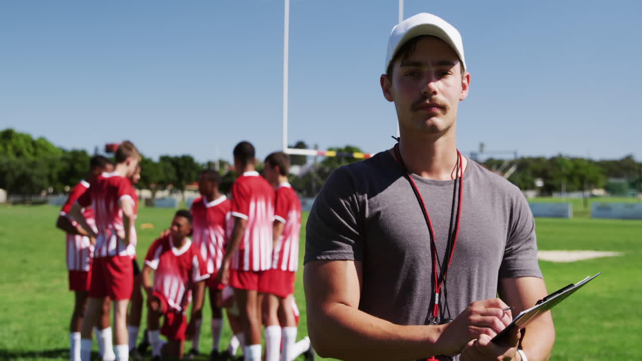 코치가 럭비 선수들의 활약을 주목하고 있다.