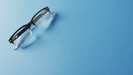 video de un par de gafas sobre un fondo azul con espacio de copia